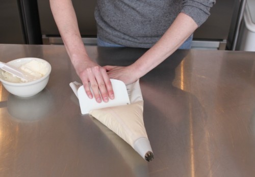 Use your bowel scraper to push all the icing down toward the tip.